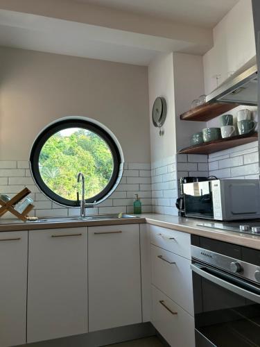 a kitchen with a sink and a window at Cosy Vaikea Lodge, Pamatai road in Faaa
