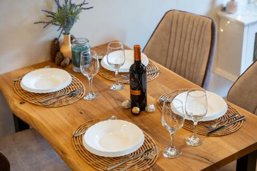 a wooden table with glasses and a bottle of wine at Apartman Andjela12 Zlatibor in Ocka Gora
