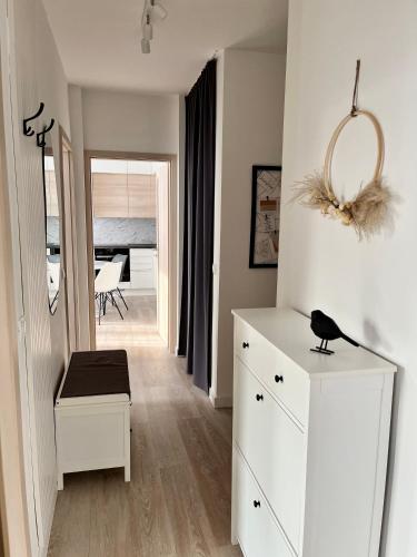 a bedroom with a white dresser and a room at Millennium Apartman Tatabánya in Tatabánya