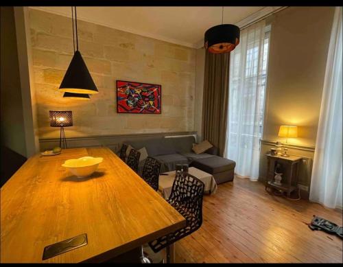 un salon avec une table en bois et un canapé dans l'établissement Appartement hyper centre historique, à Bordeaux