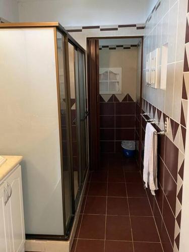 a bathroom with a shower and a tiled floor at Comparte con la Naturaleza in Escazu