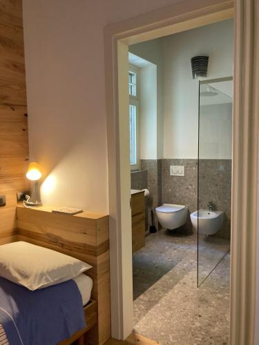 a bathroom with a bed and a tub and a sink at B&B Villa Cortese in Clusone