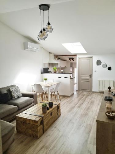 un salon avec un canapé et une table dans l'établissement Sous les toits de Millau - Appartement cosy et chaleureux, à Millau
