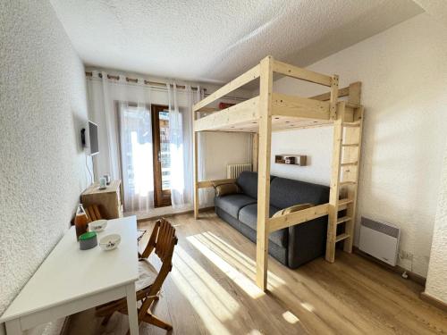 Cette petite chambre comprend des lits superposés et un bureau. dans l'établissement Résidence Le Sporting - Studio · Chaleureux · Grande terrasse MAE-1451, à La Salle Les Alpes