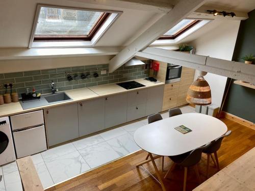 a kitchen with a white table and a white counter top at Stylish & Spacious Town Centre Duplex Apartment in Porthmadog
