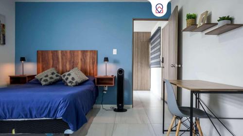 a blue bedroom with a bed and a table at Private Loft Cozy & Modern in San Luis Potosí