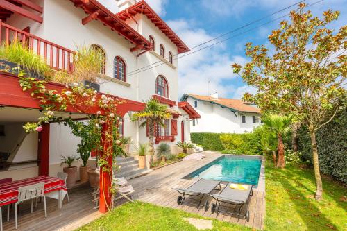une maison avec une piscine dans une cour dans l'établissement VILLA FLOW KEYWEEK - heated pool garden Biarritz, à Biarritz