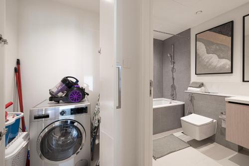 a bathroom with a washing machine and a sink at Lux Sky Residence, Burj Crown, Opera Boulevard View by Dubai Mall in Dubai