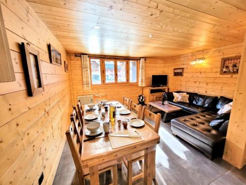 Cette chambre en bois comprend une table et un canapé. dans l'établissement Résidence Epilobe - T3+cabine au coeur du village et proche des pistes MAE-0971, aux Gets