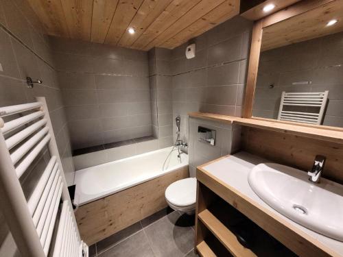 une salle de bain avec un lavabo, une baignoire et des toilettes dans l'établissement Résidence Epilobe - T3+cabine au coeur du village et proche des pistes MAE-0971, aux Gets