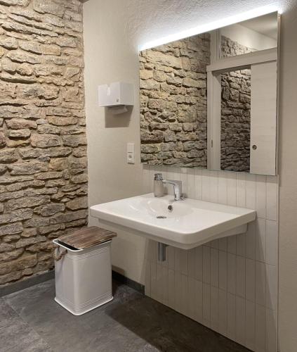 a bathroom with a sink and a mirror and a trash can at Charmantes Chateau Lichter - Burghaus in Ließem