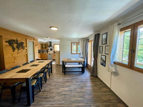 une salle à manger avec une longue table et des chaises dans l'établissement Le Tout Schuss Chalet, SPA Privé, piste de ski à 100m, à Les Deux Alpes
