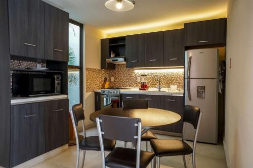 a kitchen with a table and chairs and a refrigerator at Departamento Morelos SLP Centro Historico in San Luis Potosí