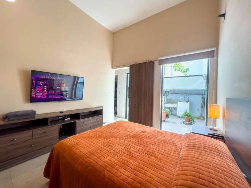 a bedroom with a bed and a flat screen tv at Departamento Morelos SLP Centro Historico in San Luis Potosí