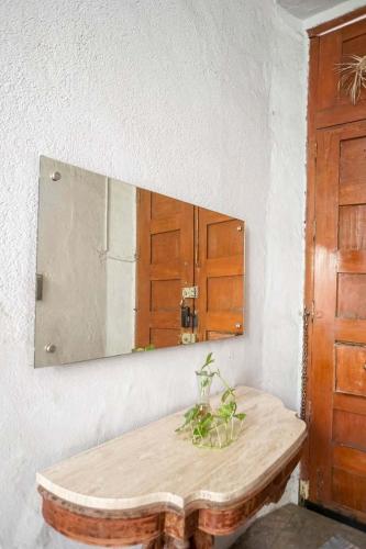 a mirror on a wall above a wooden table with a plant at Departamento Morelos SLP Centro Historico in San Luis Potosí