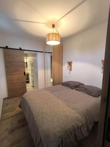 une chambre avec un grand lit et un lustre dans l'établissement A Karibu, à Saint-Médard-en-Jalles