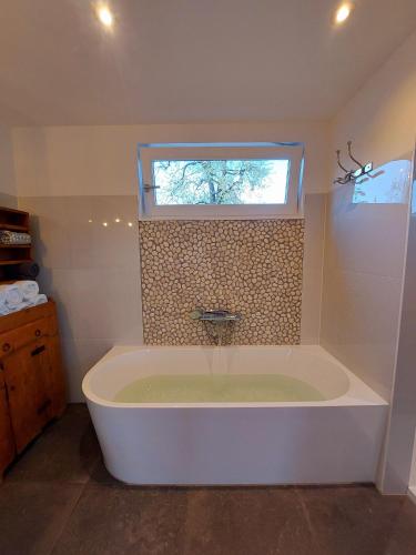a large bath tub in a bathroom with a window at BB-4u in IJsselstein