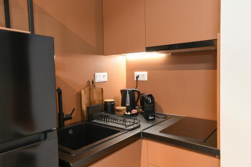 a small kitchen with a sink and a refrigerator at OMIKRON luxury living in Thessaloniki