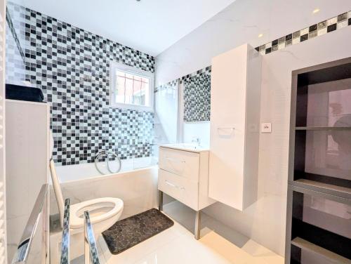 une salle de bain blanche avec des toilettes et un lavabo dans l'établissement Villa récente, à Vallauris