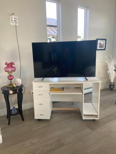 a white desk with a large tv on top of it at EdgeWater Chemainus in Chemainus