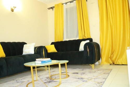 a living room with a black couch and a table at Elite stay in Embu