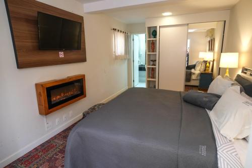 a bedroom with a bed and a tv on a wall at Pousada Orquidea da Serra in Petrópolis
