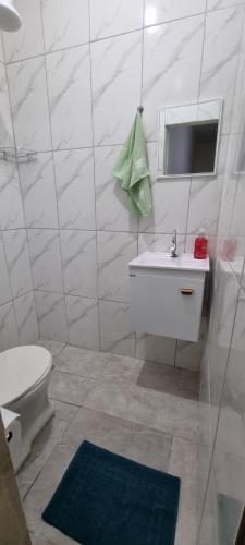 a bathroom with a toilet and a sink and a mirror at Apartamento à 250m da Basílica in Aparecida