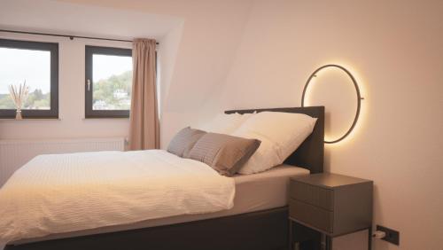una camera da letto con un letto con uno specchio e una lampada di 140qm Luxuriöses Penthouse mitten in Schwäbisch Gmünd, 70qm Dachterrasse & Top-Lage, mit WHIRPOOL, Jetzt buchen! a Schwäbisch Gmünd