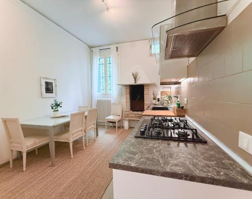 una cocina con estufa horno superior junto a una mesa en Garden Lodge by Veneto Villa, en Villa Osti