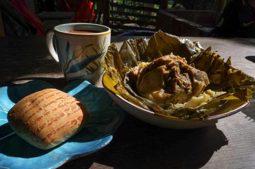 a table with a bowl of food and a cup of coffee at Alojamiento rural Ecoparque La Motilona Paicol, Huila - Cabaña Colibrí in Paicol