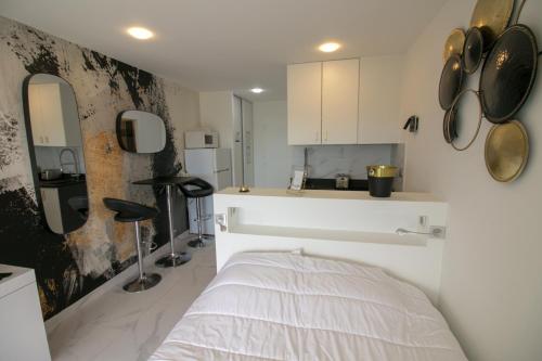 - une cuisine blanche avec un lit dans une chambre dans l'établissement CAP D'AGDE Naturiste Heliopolis - PETIT CAPRICE, au Cap d'Agde