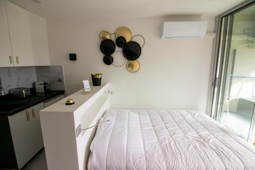 - une chambre avec un lit et un comptoir avec des poêles sur le mur dans l'établissement CAP D'AGDE Naturiste Heliopolis - PETIT CAPRICE, au Cap d'Agde