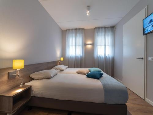 Un dormitorio con una cama grande con dos almohadas. en Villa in Zeeland near Clean Beaches, en Colijnsplaat