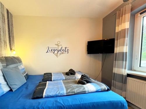 a bedroom with a blue bed with a sign on the wall at STANMA Heimat am Meer 100 m zum Meer mit Strandkorb in Büsumer Deichhausen