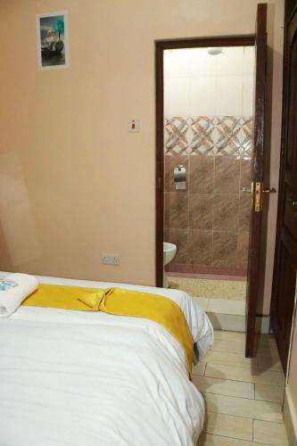 a bedroom with a bed and a bathroom with a shower at Elite stay in Embu