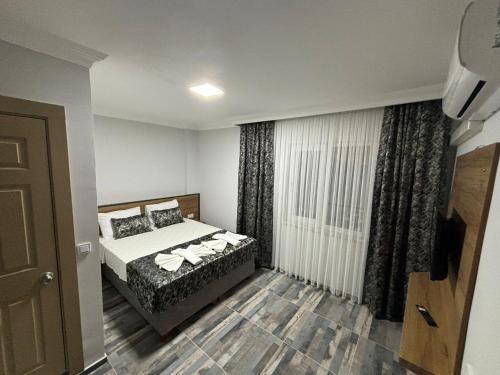 a bedroom with a bed and a window with curtains at Akapella in Pamukkale