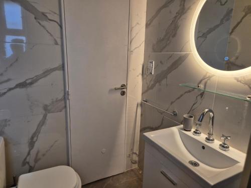 a bathroom with a sink and a toilet and a mirror at Moderno y Acogedor I in Mar del Plata