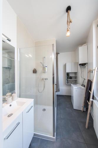 a white bathroom with a shower and a sink at BALI SPA détente à deux à 5 minutes de Tours centre in Tours