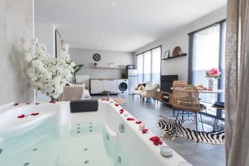 a large white bath tub in a living room at BALI SPA détente à deux à 5 minutes de Tours centre in Tours
