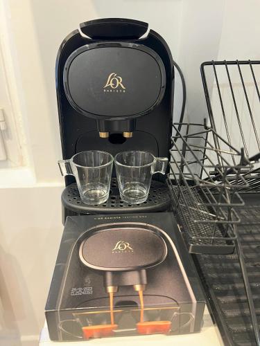 a black coffee maker with two glasses on it at Paris Secret Spot - Loft Unique aux portes de Paris in Gentilly