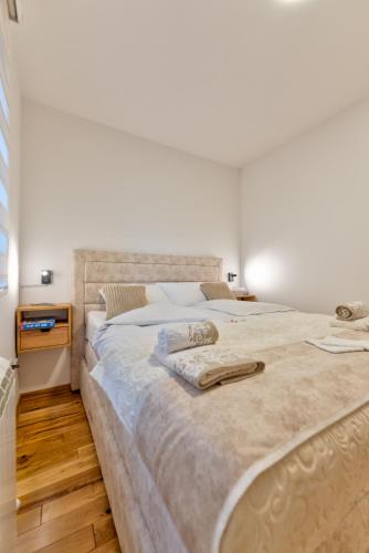 a bedroom with a large bed with two towels on it at Apartman Andjela12 Zlatibor in Ocka Gora