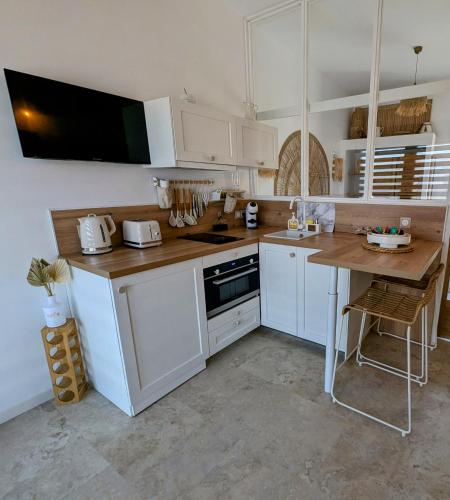 une cuisine avec des armoires blanches et une table en bois dans l'établissement Kabana, à Groffliers