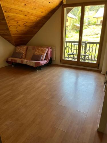 Cette chambre comprend un lit et une grande fenêtre. dans l'établissement Studio 2 personnes, à Val-des-Prés