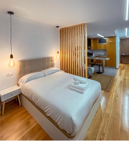 a bedroom with a large white bed with towels on it at Las Terrazas de Vigo - Paula in Vigo