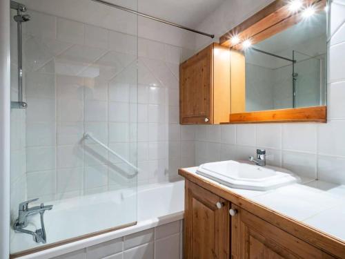 une salle de bain avec un lavabo, une baignoire et un miroir dans l'établissement Résidence Moraine - MORAINE 11 MAE-4441, à Les Allues