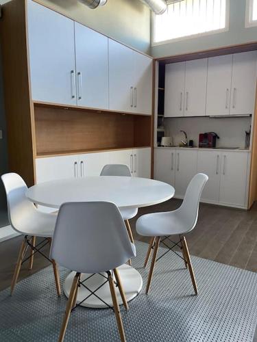 a kitchen with a white table and white chairs at Loft acogedor in Seville