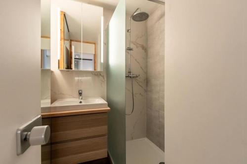 une salle de bain avec un lavabo et une douche avec un miroir dans l'établissement Résidence Saint Jacques - Résidence LE SAINT JACQUES N°206 MAE-4911, à La Plagne Tarentaise