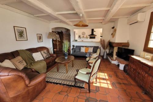 Elle comprend un salon doté d'un mobilier en cuir et d'une cheminée. dans l'établissement Villa Benni - Swimming pool mountain view - Happy Rentals, à Levens