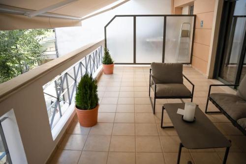 a balcony of a building with chairs and a table at Υπέροχο διαμέρισμα με πάρκινγκ in Larisa