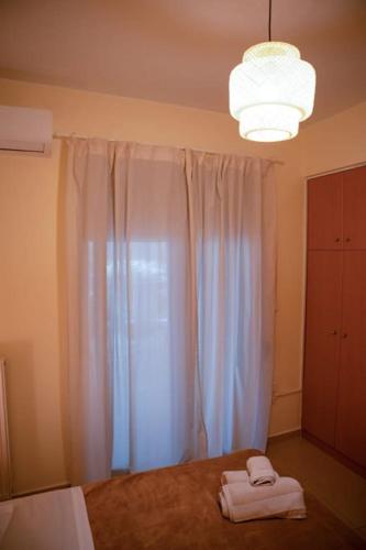 a bedroom with a bed and a white curtain at Υπέροχο διαμέρισμα με πάρκινγκ in Larisa